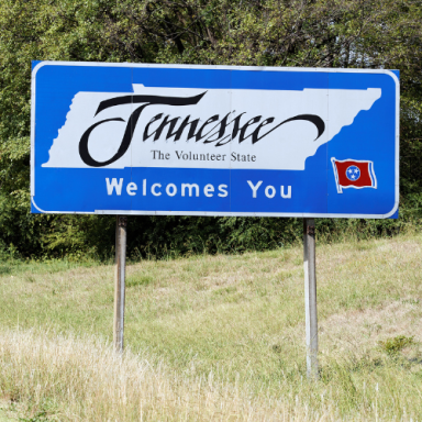 Welcome sign for Tennessee, featuring the state name and flag.