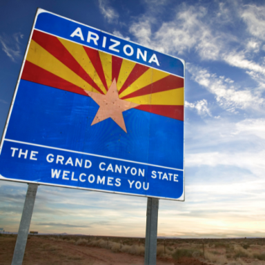 Welcome sign for Arizona, featuring a star and the text "The Grand Canyon State."