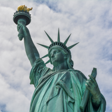 Statue of Liberty holding a torch against a cloudy sky.